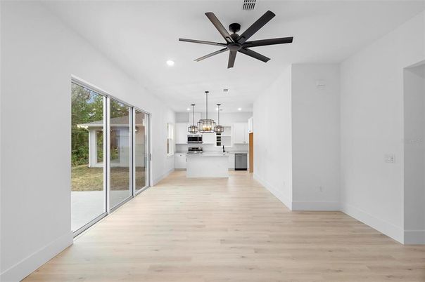 Empty room, Interior, Kitchen, Pendant Lights, Recessed Lighting, Stainless Steel Appliances, Wood Texture Flooring