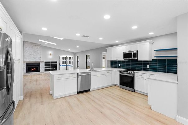 Fireplace, Interior, Kitchen, Recessed Lighting, Stainless Steel Appliances, Stone Walls, Wood Texture Flooring