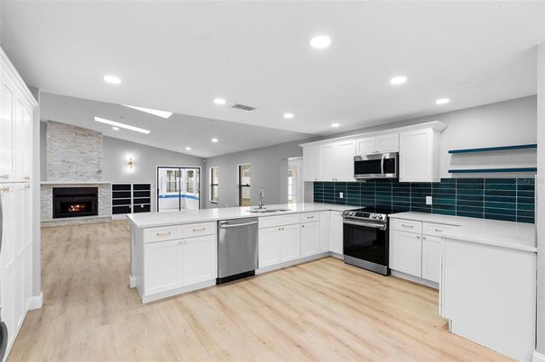 Fireplace, Interior, Kitchen, Recessed Lighting, Stainless Steel Appliances, Stone Walls, Wood Texture Flooring