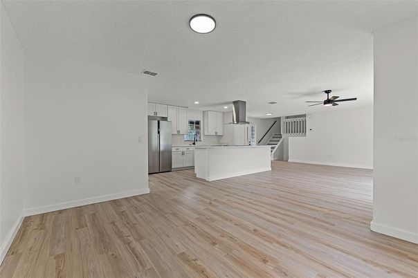 Empty room, Interior, Kitchen, Recessed Lighting, Stainless Steel Appliances, Wood Texture Flooring