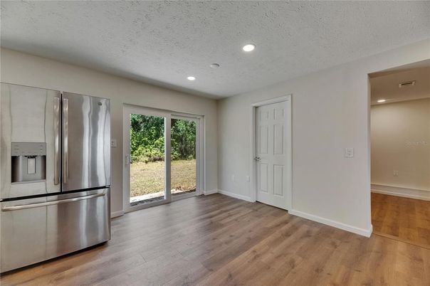Empty room, Interior, Kitchen, Recessed Lighting, Stainless Steel Appliances, Wood Texture Flooring