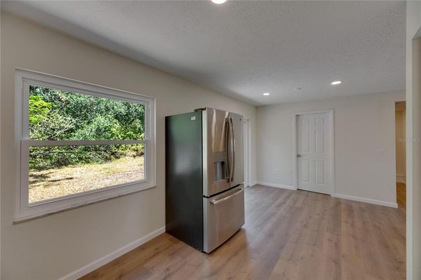 Empty room, Interior, Kitchen, Recessed Lighting, Stainless Steel Appliances, Wood Texture Flooring