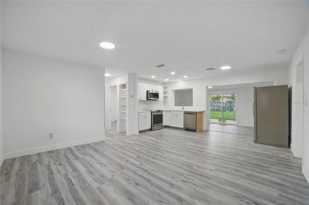 Empty room, Interior, Kitchen, Recessed Lighting, Stainless Steel Appliances, Wood Texture Flooring