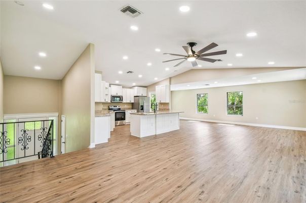 Empty room, Interior, Kitchen, Recessed Lighting, Stainless Steel Appliances, Wood Texture Flooring