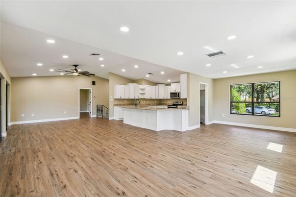 Empty room, Interior, Kitchen, Recessed Lighting, Stainless Steel Appliances, Wood Texture Flooring