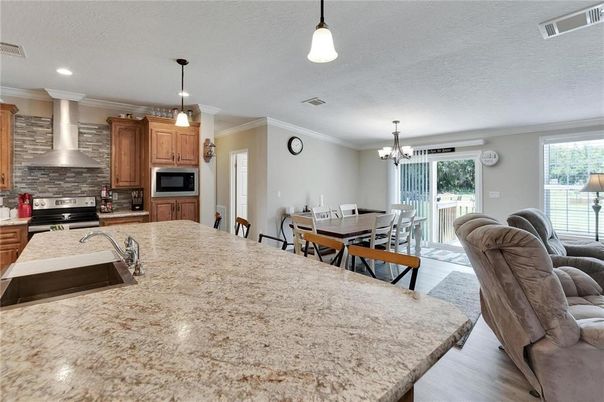 Chandelier, Dining room, Interior, Kitchen, Living room, Pendant Lights, Recessed Lighting, Stainless Steel Appliances, Wood Texture Flooring