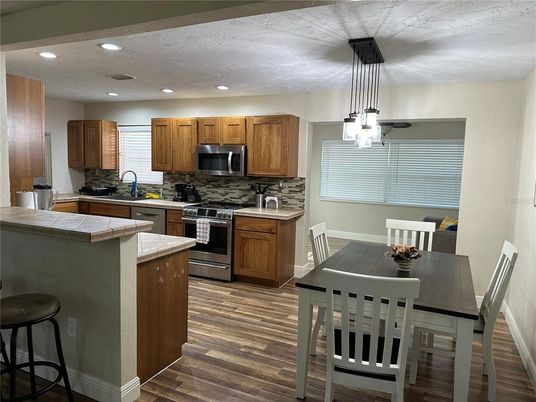 Dining room, Interior, Kitchen, Pendant Lights, Recessed Lighting, Stainless Steel Appliances, Wood Texture Flooring