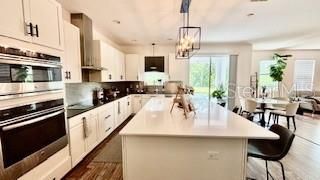 Chandelier, Dining room, Interior, Kitchen, Pendant Lights, Recessed Lighting, Stainless Steel Appliances, Wood Texture Flooring