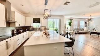 Chandelier, Dining room, Interior, Kitchen, Living room, Pendant Lights, Recessed Lighting, Stainless Steel Appliances, Wood Texture Flooring
