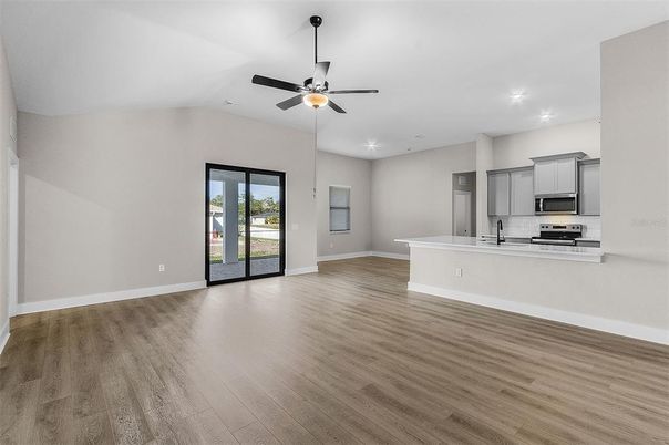Empty room, Interior, Kitchen, Recessed Lighting, Stainless Steel Appliances, Wood Texture Flooring
