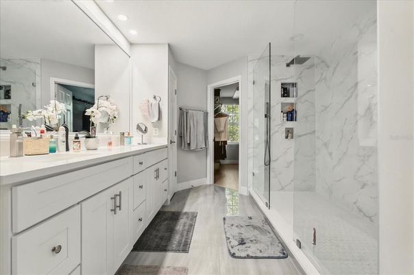 Bathroom, Dual Sink Vanities, Glass Shower, Interior, Marble Walls, Recessed Lighting, Wood Texture Flooring