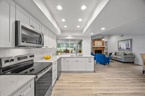 Fireplace, Interior, Kitchen, Living room, Recessed Lighting, Stainless Steel Appliances, Wood Texture Flooring