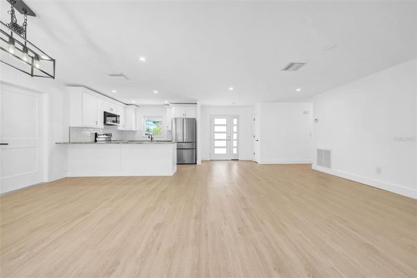 Empty room, Interior, Kitchen, Recessed Lighting, Stainless Steel Appliances, Wood Texture Flooring