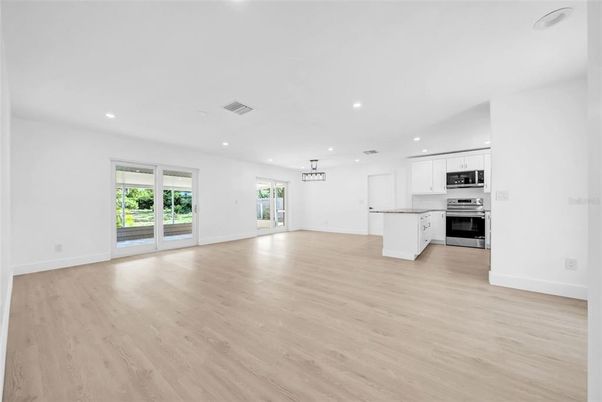 Empty room, Interior, Kitchen, Pendant Lights, Recessed Lighting, Stainless Steel Appliances, Wood Texture Flooring