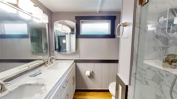 Bathroom, Dual Sink Vanities, Glass Shower, Interior, Marble Walls, Wood Texture Flooring