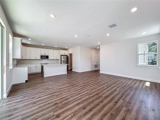 Empty room, Interior, Kitchen, Recessed Lighting, Stainless Steel Appliances, Wood Texture Flooring