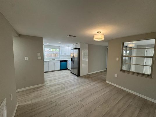 Empty room, Interior, Kitchen, Recessed Lighting, Stainless Steel Appliances, Wood Texture Flooring