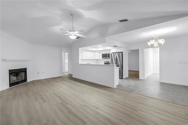 Chandelier, Empty room, Fireplace, Interior, Kitchen, Stainless Steel Appliances, Wood Texture Flooring