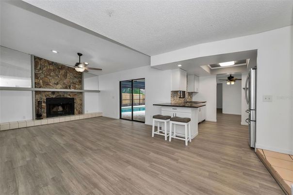 Empty room, Fireplace, Interior, Kitchen, Recessed Lighting, Stone Walls, Wood Texture Flooring