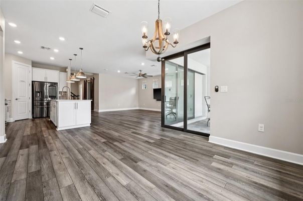 Chandelier, Empty room, Interior, Kitchen, Pendant Lights, Recessed Lighting, Stainless Steel Appliances, Wood Texture Flooring