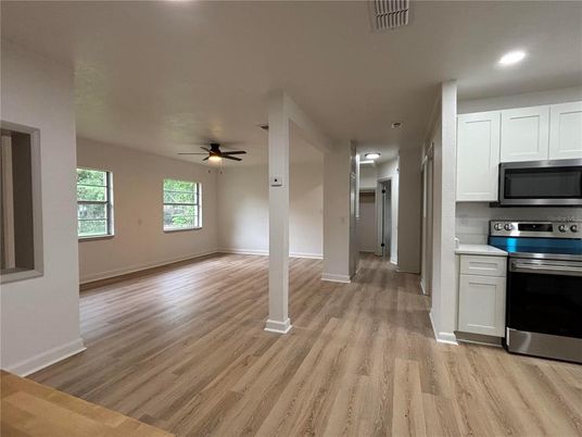 Empty room, Interior, Kitchen, Recessed Lighting, Stainless Steel Appliances, Wood Texture Flooring