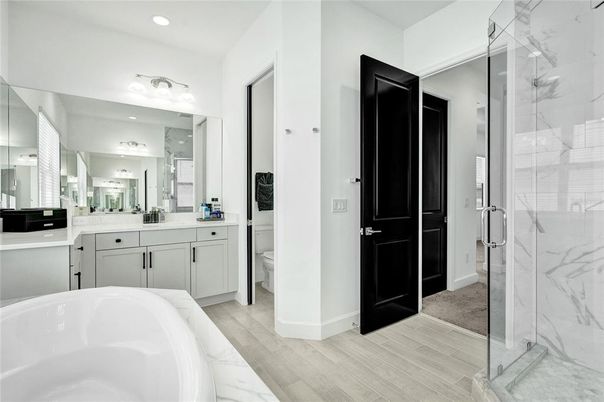 Bathroom, Dual Sink Vanities, Free Standing Baths, Glass Shower, Interior, Marble Walls, Recessed Lighting, Wood Texture Flooring