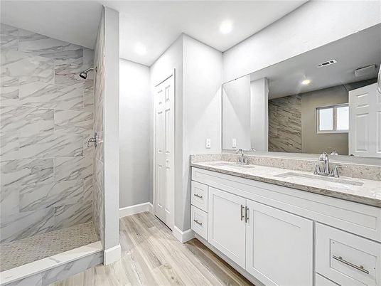 Bathroom, Dual Sink Vanities, Glass Shower, Interior, Marble Walls, Recessed Lighting, Wood Texture Flooring