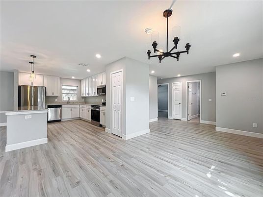 Chandelier, Empty room, Interior, Kitchen, Pendant Lights, Recessed Lighting, Stainless Steel Appliances, Wood Texture Flooring