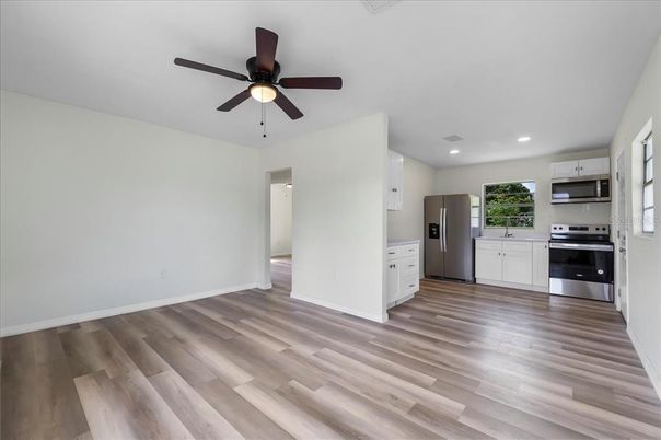 Empty room, Interior, Kitchen, Recessed Lighting, Stainless Steel Appliances, Wood Texture Flooring