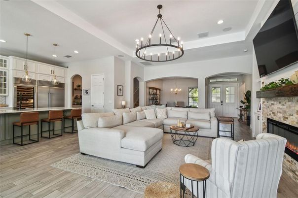Chandelier, Fireplace, Interior, Kitchen, Living room, Pendant Lights, Recessed Lighting, Stainless Steel Appliances, Stone Walls, Wood Texture Flooring
