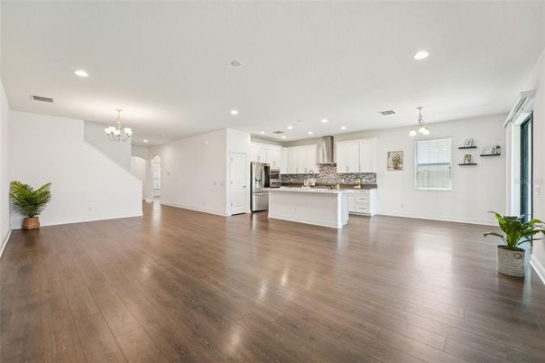 Chandelier, Empty room, Interior, Kitchen, Pendant Lights, Recessed Lighting, Stainless Steel Appliances, Wood Texture Flooring