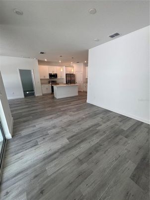 Empty room, Interior, Kitchen, Pendant Lights, Recessed Lighting, Stainless Steel Appliances, Wood Texture Flooring