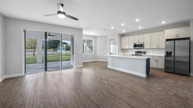 Empty room, Interior, Kitchen, Recessed Lighting, Stainless Steel Appliances, Wood Texture Flooring