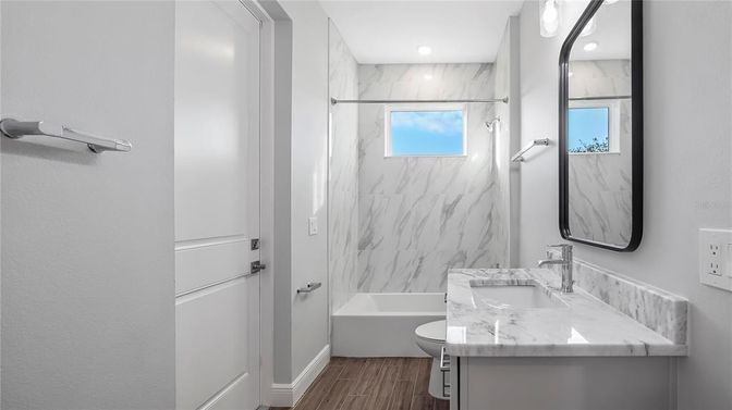 Bathroom, Dual Sink Vanities, Interior, Marble Walls, Recessed Lighting, Wood Texture Flooring
