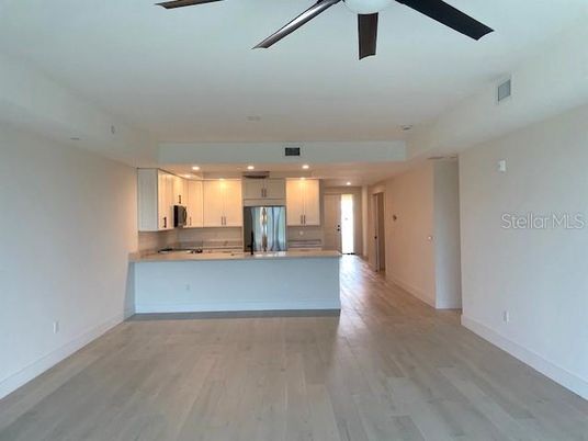 Empty room, Interior, Kitchen, Recessed Lighting, Stainless Steel Appliances, Wood Texture Flooring