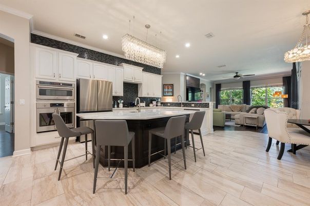 Chandelier, Dining room, Interior, Kitchen, Living room, Pendant Lights, Recessed Lighting, Stainless Steel Appliances, Wood Texture Flooring