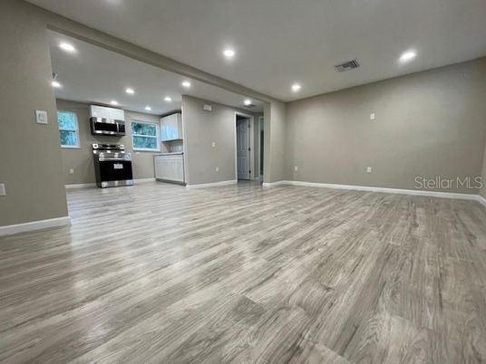 Empty room, Interior, Kitchen, Recessed Lighting, Stainless Steel Appliances, Wood Texture Flooring
