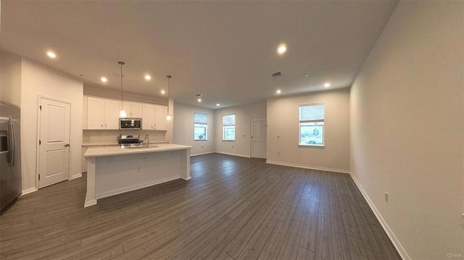Empty room, Interior, Kitchen, Pendant Lights, Recessed Lighting, Stainless Steel Appliances, Wood Texture Flooring