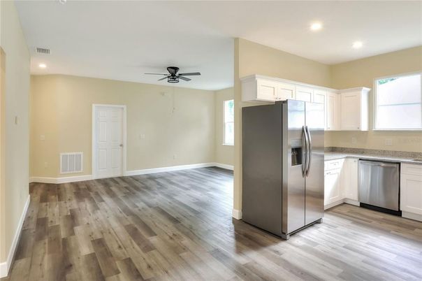 Empty room, Interior, Kitchen, Recessed Lighting, Stainless Steel Appliances, Wood Texture Flooring