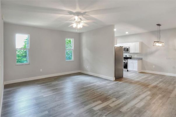 Empty room, Interior, Kitchen, Pendant Lights, Recessed Lighting, Stainless Steel Appliances, Wood Texture Flooring