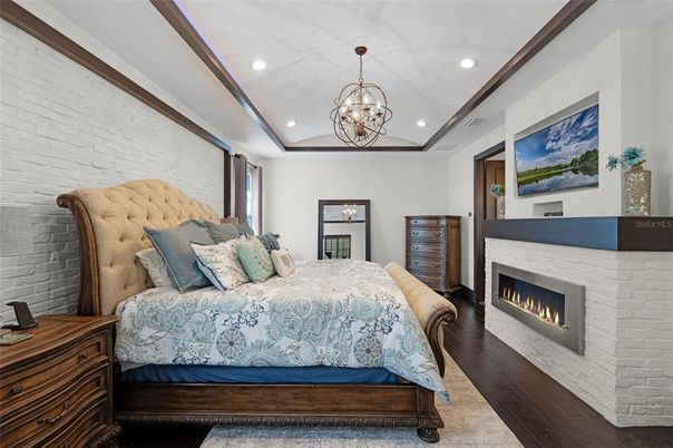 Bedroom, Chandelier, Fireplace, Interior, Recessed Lighting, Stone Walls, Wood Texture Flooring