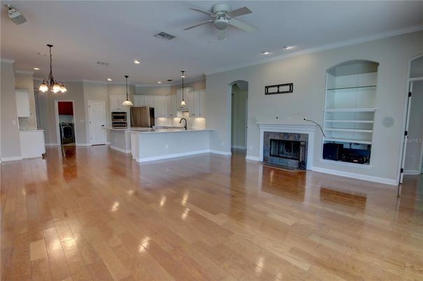 Empty room, Fireplace, Interior, Kitchen, Pendant Lights, Recessed Lighting, Stainless Steel Appliances, Wood Texture Flooring