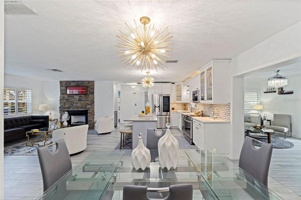 Chandelier, Dining room, Fireplace, Interior, Kitchen, Living room, Pendant Lights, Stainless Steel Appliances, Stone Walls