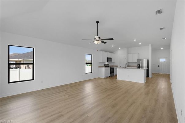 Empty room, Interior, Kitchen, Recessed Lighting, Stainless Steel Appliances, Wood Texture Flooring