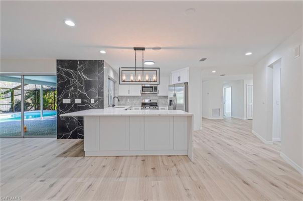 Interior, Kitchen, Marble Walls, Pendant Lights, Recessed Lighting, Stainless Steel Appliances, Wood Texture Flooring