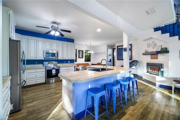 Fireplace, Interior, Kitchen, Pendant Lights, Recessed Lighting, Stainless Steel Appliances, Tile Countertops, Wood Texture Flooring