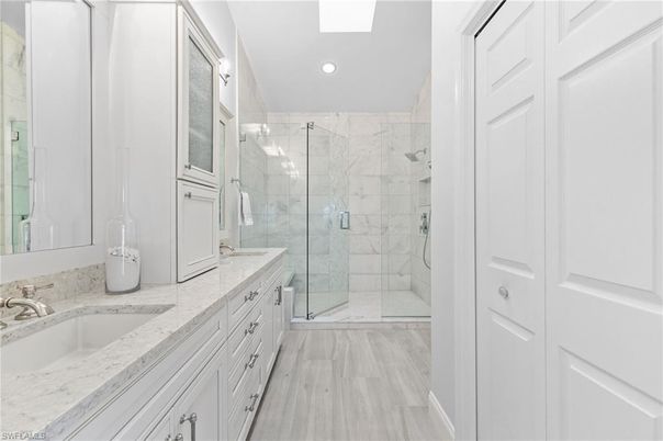 Bathroom, Dual Sink Vanities, Glass Shower, Interior, Marble, Marble Walls, Recessed Lighting, Wood Texture Flooring