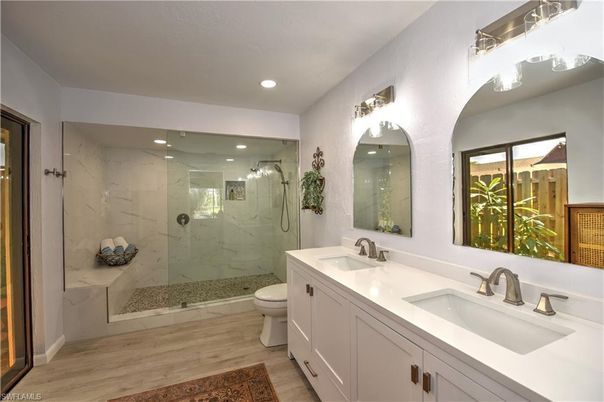Bathroom, Dual Sink Vanities, Glass Shower, Interior, Marble Walls, Recessed Lighting, Wood Texture Flooring