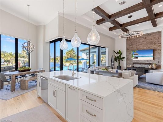Chandelier, Dining room, Fireplace, Interior, Kitchen, Living room, Pendant Lights, Recessed Lighting, Stainless Steel Appliances, Stone Walls, Wooden Beams, Wood Texture Flooring