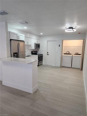 Interior, Kitchen, Recessed Lighting, Washer, Wood Texture Flooring